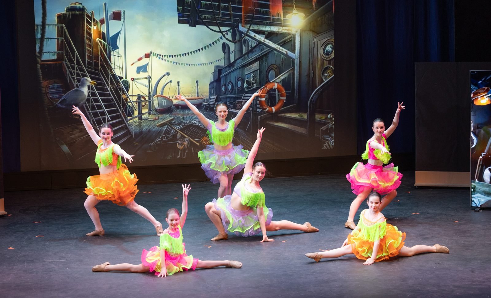 Bravo jazz dancers in bright costumes posing on stage